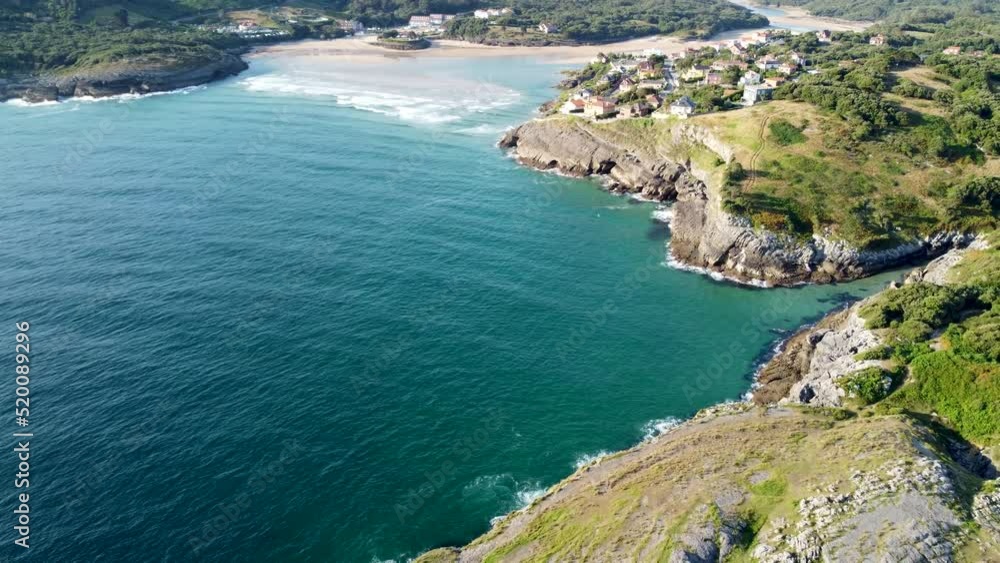 aerial view with drone of the cantabrian coast with the sea entering and the village in the background with the beach on a sunny day. aerial view with drone of the cantabrian coast with the sea entering and the village in the background with the beach on a sunny day.
