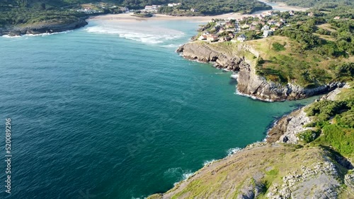 aerial view with drone of the cantabrian coast with the sea entering and the village in the background with the beach on a sunny day.