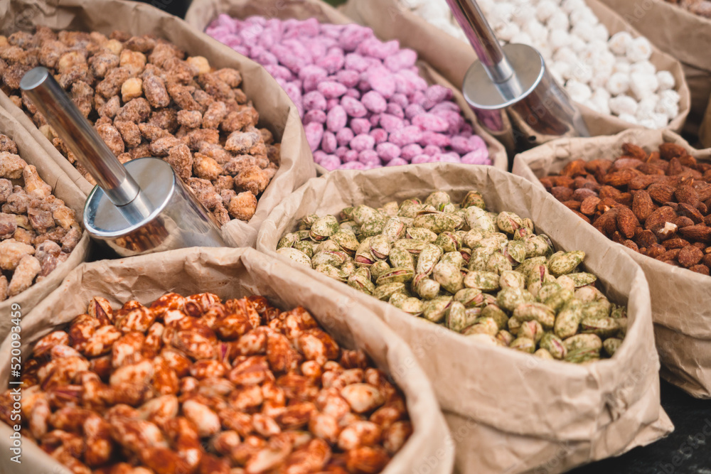 Different types of nuts in paper bags are sold in the street market