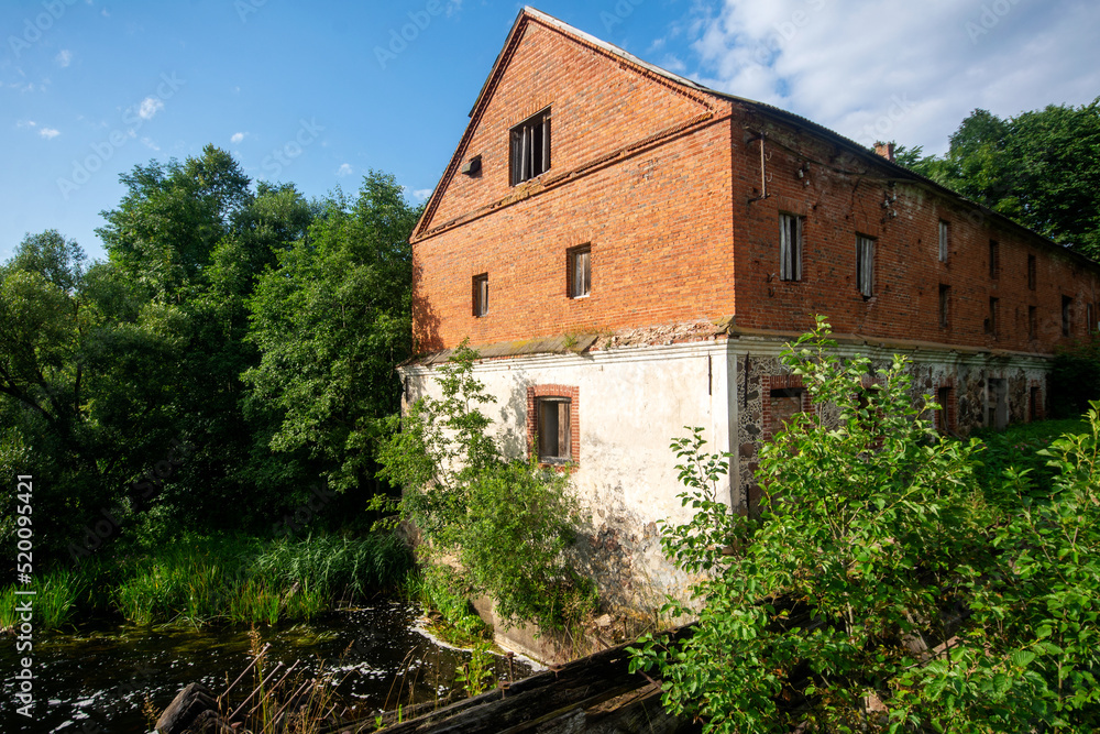 Old abandoned red brick watermill. Architectural monument of the 19th century.