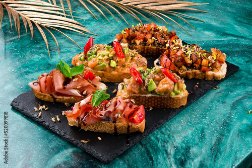 various bruschettas with toppings on marble. Snack finger food meal for wine, italian starter.