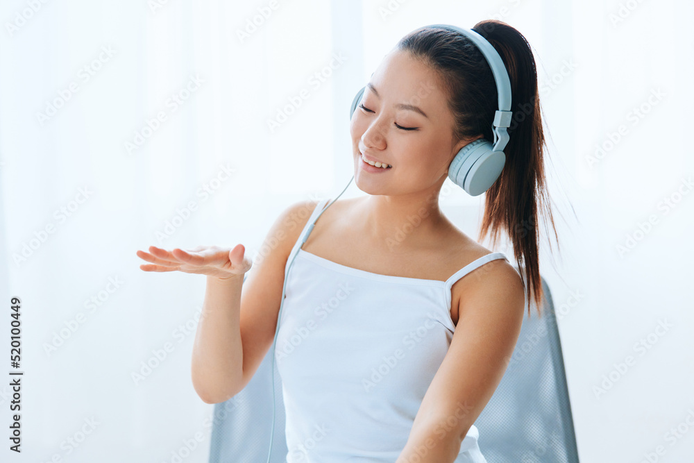 Enjoyed favorite playlist tanned lovely young Asian woman in headphones closing eyes relax at home interior living room. Sound Studio Stream, Social media concept. Cool offer Banner Wide angle Enjoyed favorite playlist tanned lovely young Asian woman in headphones closing eyes relax at home interior living room. Sound Studio Stream, Social media concept. Cool offer Banner Wide angle