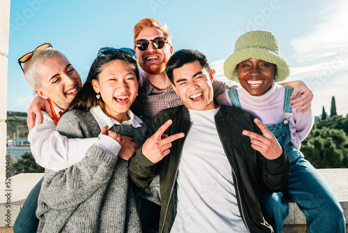 Multiracial group of friends smiling posing in front of the camera for a picture.