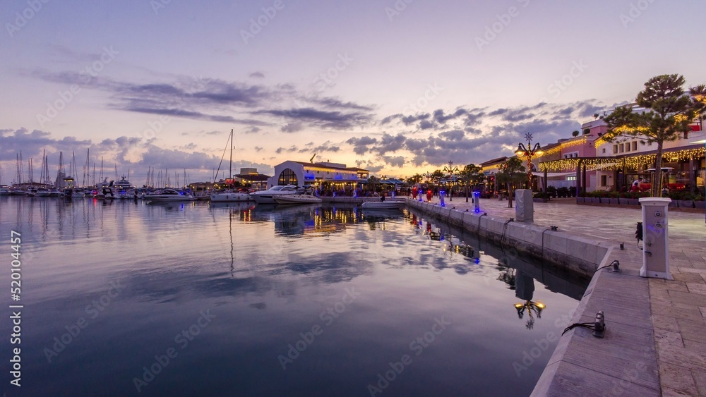 Beautiful Marina, Limassol city Cyprus. Modern, high end life in newly developed port with docked yachts, restaurants, shops, a landmark for waterfront promenade. View of the commercial area at sunset