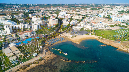 Aerial bird's eye view Pernera beach Protaras, Paralimni, Famagusta, Cyprus. The tourist attraction golden sand bay with sunbeds, water sports, hotels, restaurants, people swimming in sea from above.	