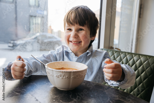 Wallpaper Mural Boy sitting at the cafe with a big bowl of soup and laughing Torontodigital.ca