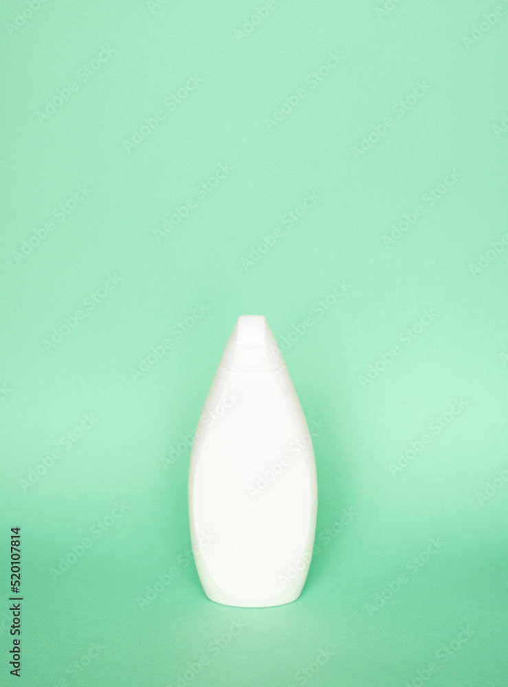 White plastic shampoo bottle isolated on green background. Skin care lotion. Bathing essential product. Shampoo bottle. Bath and body lotion. Fine liquid hand wash. White plastic shampoo bottle isolated on green background. Skin care lotion. Bathing essential product. Shampoo bottle. Bath and body lotion. Fine liquid hand wash.