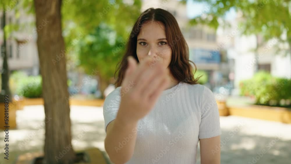 Young woman smiling confident doing coming gesture with hands at park Young woman smiling confident doing coming gesture with hands at park