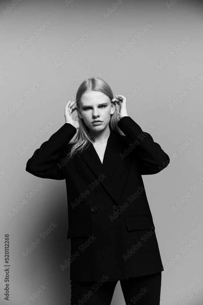 A cool hot offer for brands. A girl in a designer suit poses in a studio A cool hot offer for brands. A girl in a designer suit poses in a studio