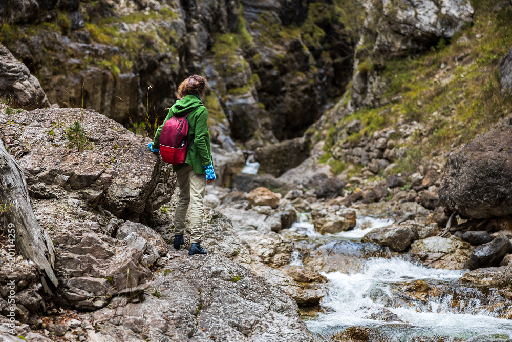 Hiking on Alpine Riverbed Uphill for a Backpack Adventurous Woman