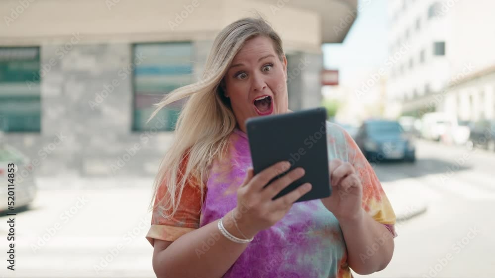 Young woman using touchpad with winner expression at street Young woman using touchpad with winner expression at street