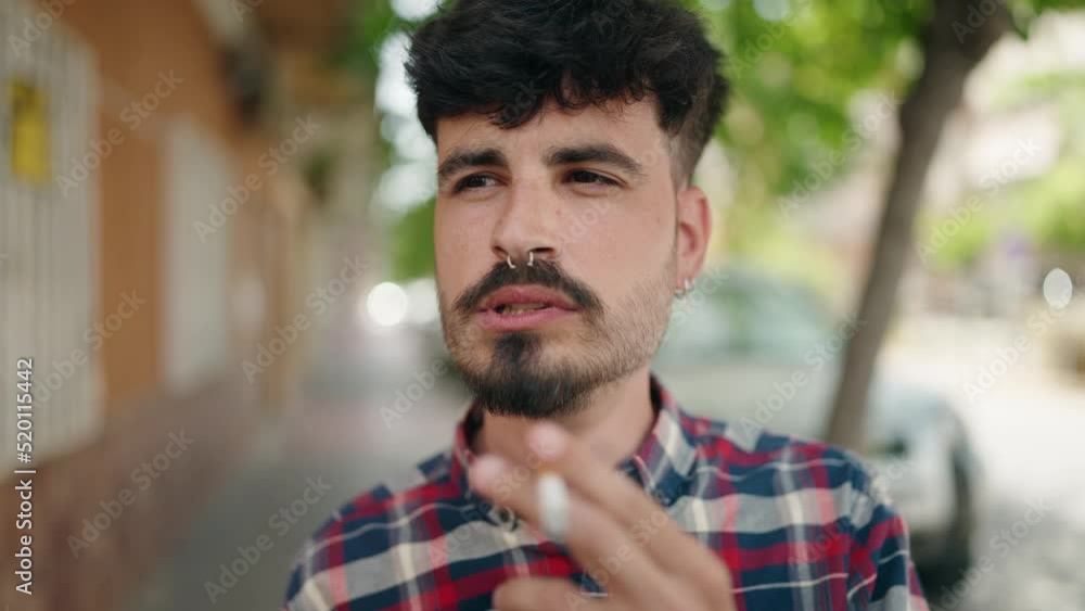 Young hispanic man smoking at street Young hispanic man smoking at street