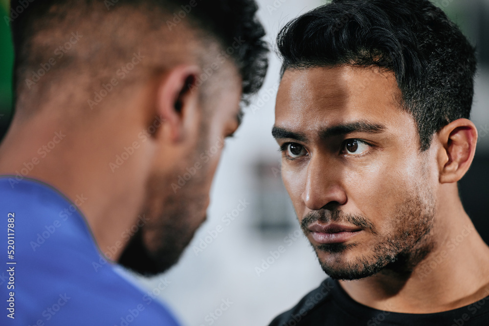 Fototapeta premium Serious, strong and fit male athletes staring, facing and looking tough. Closeup face of two men ready to challenge and battle against their teams before a fight, match or competition