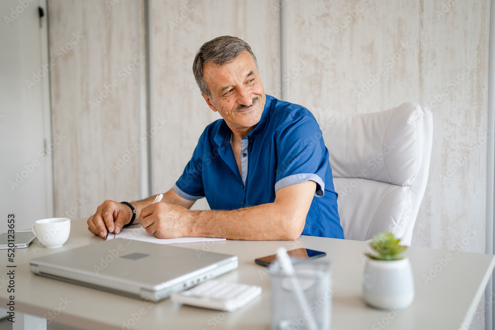 senior caucasian man working at the desk table at the office or home senior caucasian man working at the desk table at the office or home