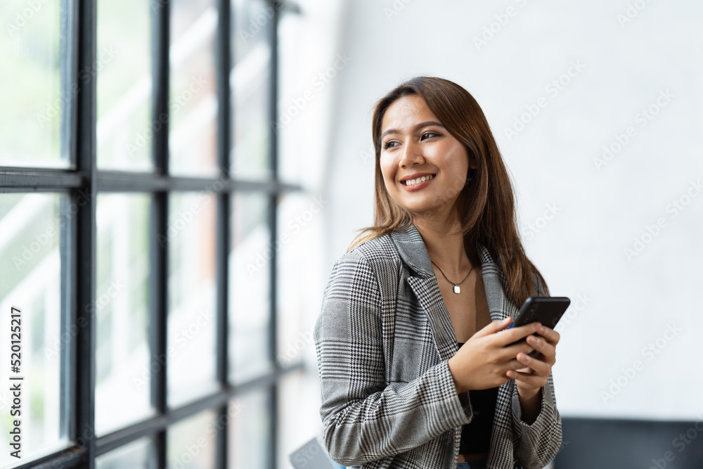 Asian businesswoman in formal suit in office happy and cheerful during using smartphone and working. Asian businesswoman in formal suit in office happy and cheerful during using smartphone and working.
