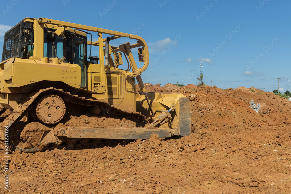 While doing landscaping work on a construction site, bulldozer works with soil from the earth bulldozer leveling ground While doing landscaping work on a construction site, bulldozer works with soil from the earth bulldozer leveling ground