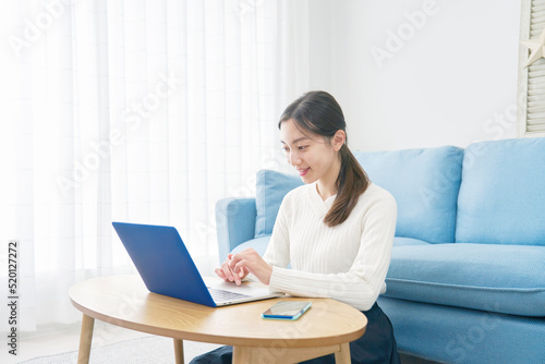 リビングでノートパソコンを使う女性