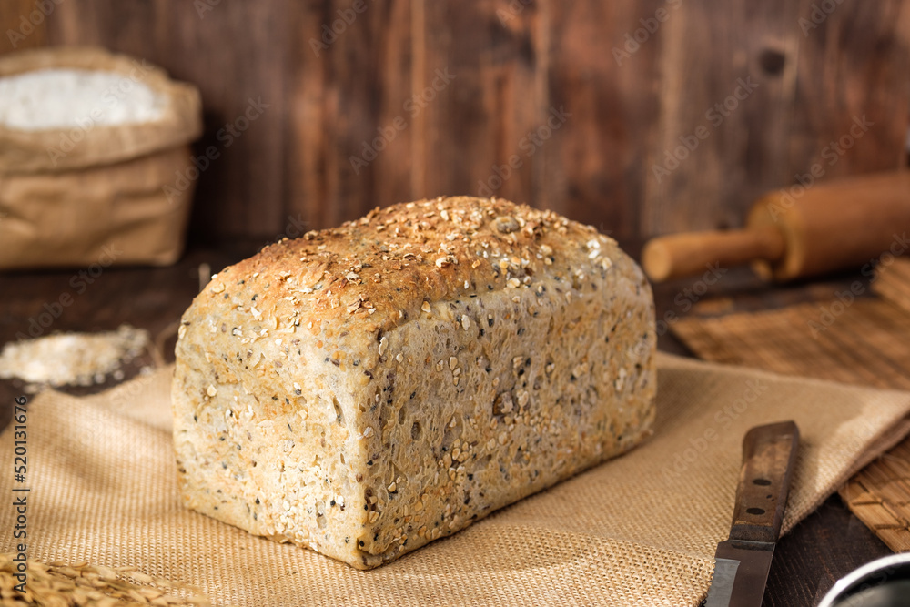 whole wheat baking bread with grains for healthy eating on wood table in kitchen whole wheat baking bread with grains for healthy eating on wood table in kitchen