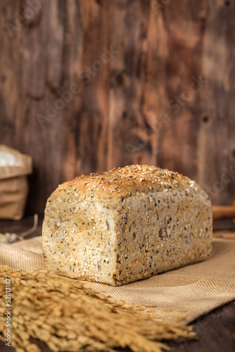 whole wheat baking bread with grains for healthy eating on wood table in kitchen