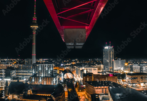 night time photography of berlin alexanderplatz city center from a crane looking on to the main square and tv tower or fernsehturm with bright lights and traffic