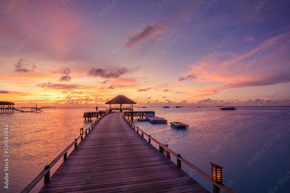 Amazing beach landscape. Beautiful Maldives sunset seascape view. Horizon colorful sea sky clouds, over water villa pier pathway. Tranquil island lagoon, tourism travel background. Exotic vacation