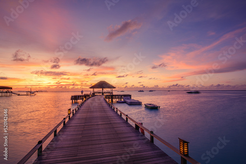 Amazing beach landscape. Beautiful Maldives sunset seascape view. Horizon colorful sea sky clouds  over water villa pier pathway. Tranquil island lagoon  tourism travel background. Exotic vacation