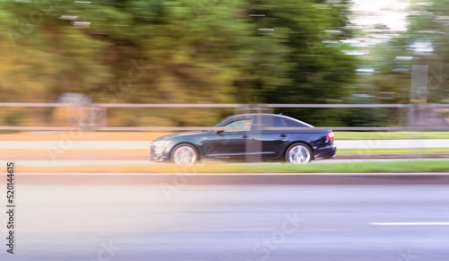 Dark car driving on the street at sunset.  motion blur © Gints 