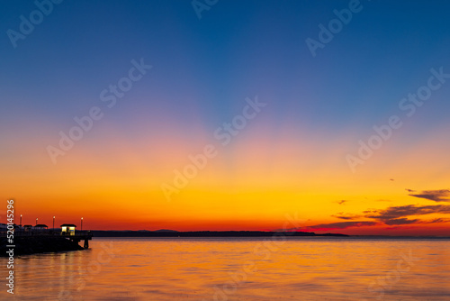 A colorful sunset over Puget Sound with crepuscular rays banding across the sky  © Harrison