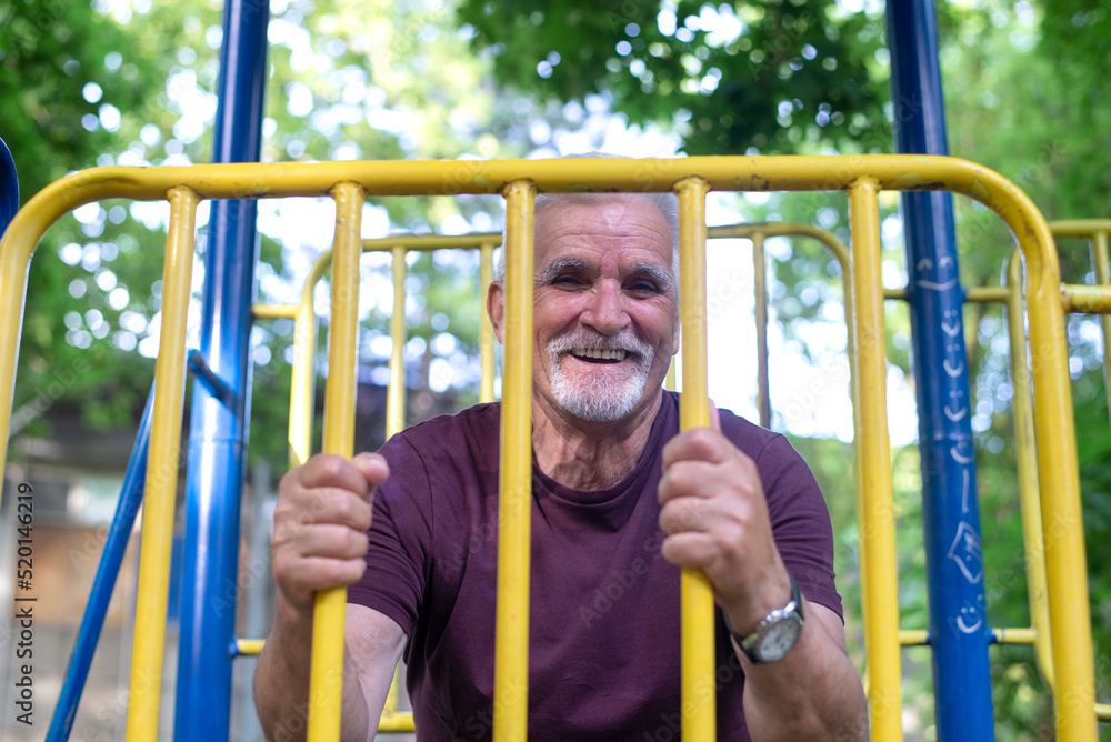 Obraz premium Happy sporty senior man stretching in the morning before exercise.