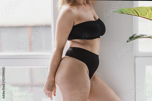 Fotografía young overweight woman in sports minimalist black lingerie poses  near large window