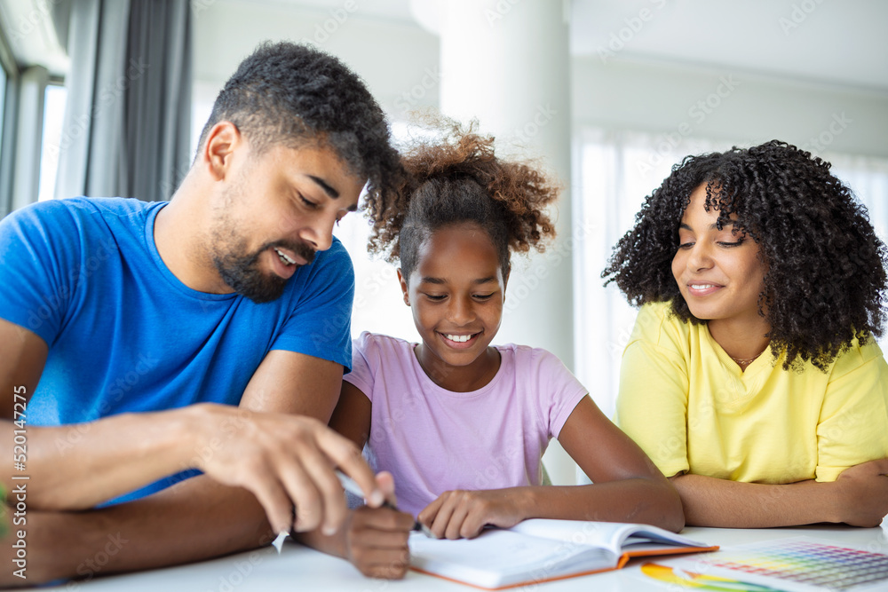 Multiethnic parents helping daughter with her homework at home. Young father and mother helping daughter study at living room. Little girl completing their exercises with the help of dad and mom.