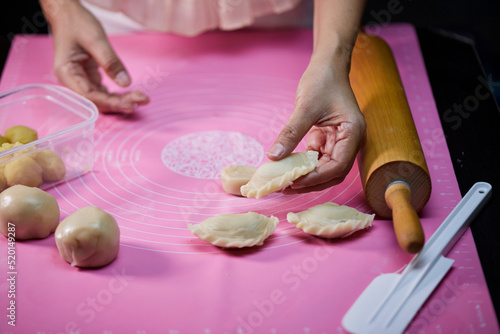 Cropped view of woman's hands are shaping the dough of curry puff