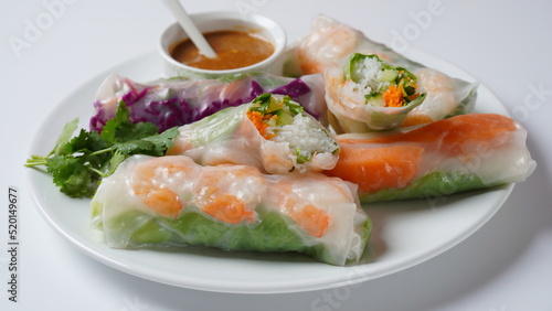 Vietnamese Spring Rolls Goi Cuon or Nem Cuon, filled with prawns, herbs, rice vermicelli and vegetables. Served with hoisin and peanut sauce dip.