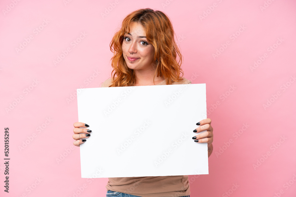 Young caucasian woman isolated on pink background holding an empty placard Young caucasian woman isolated on pink background holding an empty placard