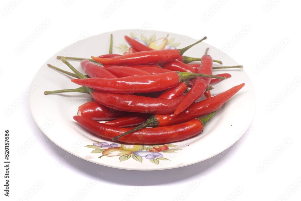 white background Fresh red peppers are placed in a white plate. white background Fresh red peppers are placed in a white plate.