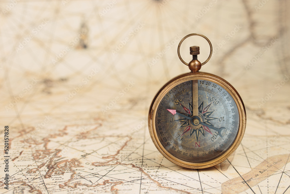 Old vintage compass on ancient map background. Travel, geography, navigation concept