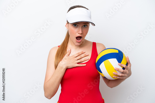 Young caucasian woman playing volleyball isolated on white background surprised and shocked while looking right