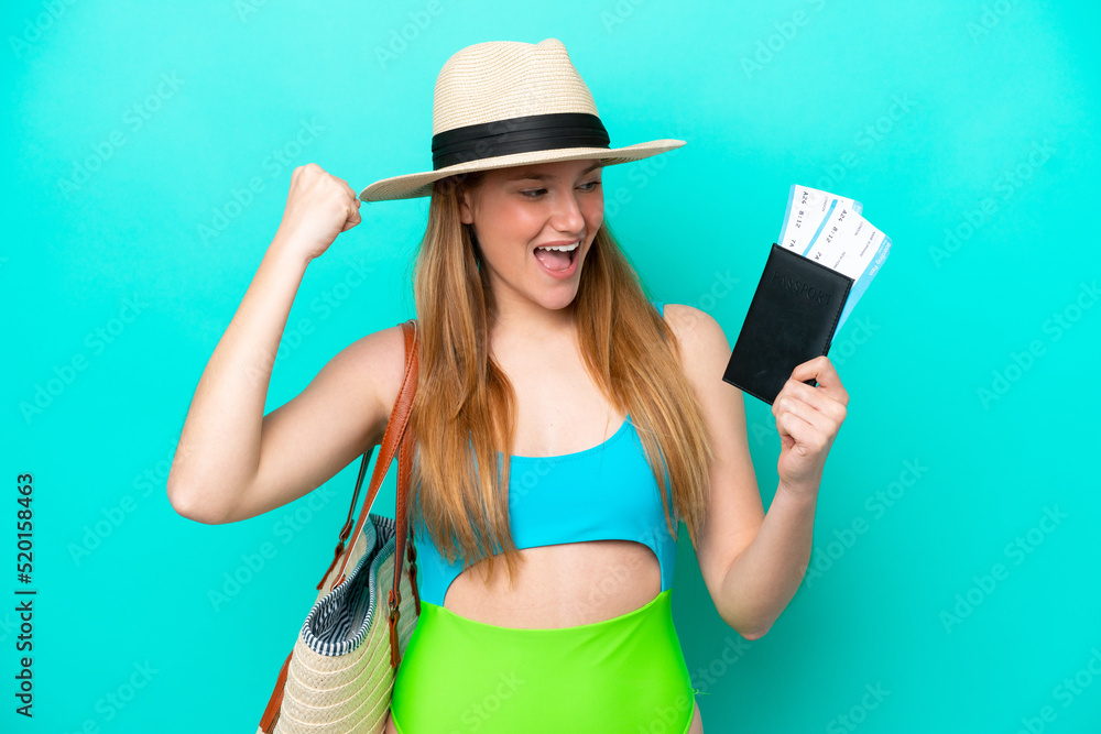 Traveler caucasian woman holding passport isolated on blue background celebrating a victory Traveler caucasian woman holding passport isolated on blue background celebrating a victory