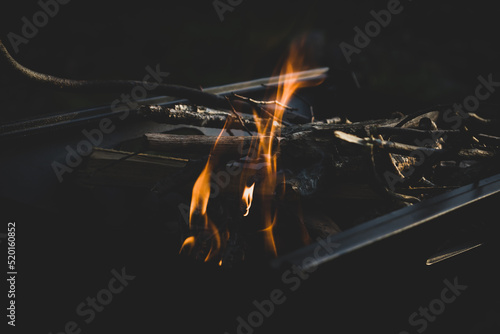 lighting a fire on the grill. camping by the lake during sunset photo