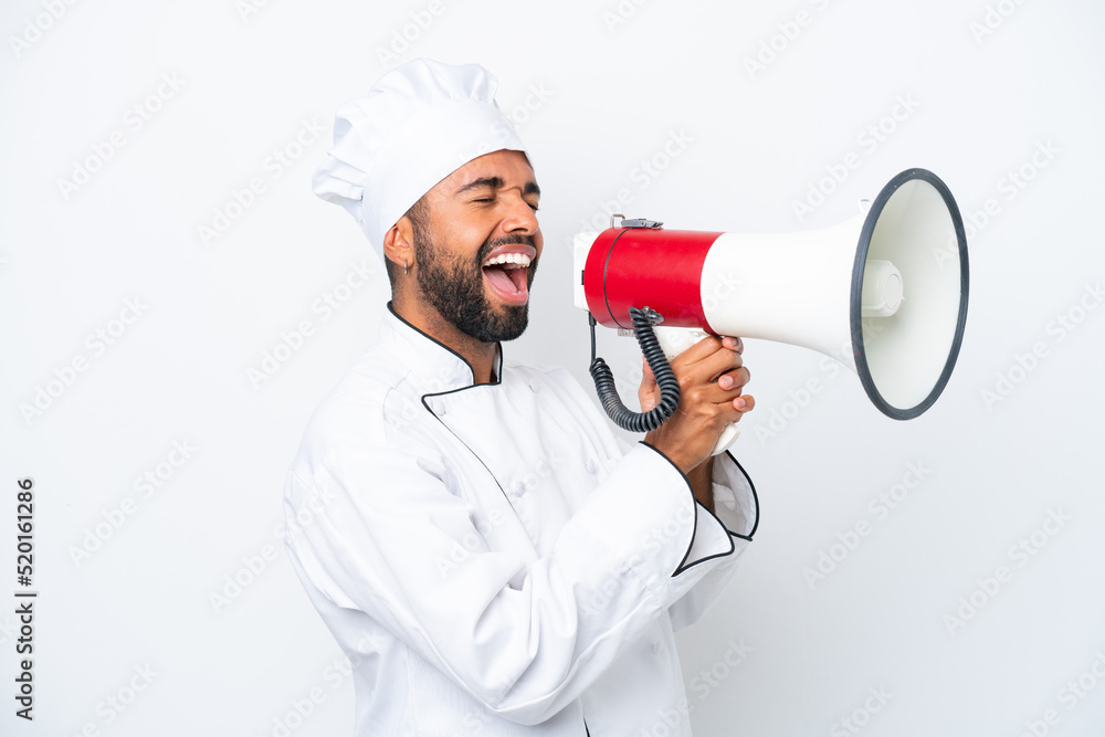 Young Brazilian chef man isolated on white background shouting through a megaphone Young Brazilian chef man isolated on white background shouting through a megaphone