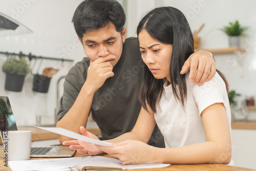 Stressed asian young couple family, wife and husband confused by calculate expense from invoice or bill, have no money to pay. Mortgage, loan causing debt, bankruptcy. Debt problems, Financial people.