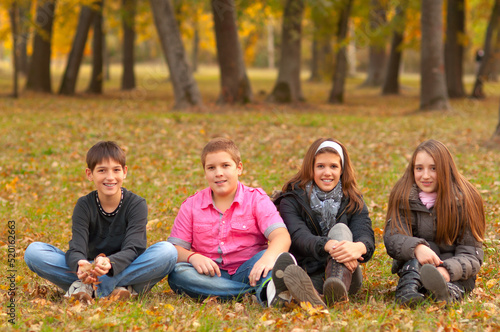 Four teenage boys and girls playing in the autumn nature