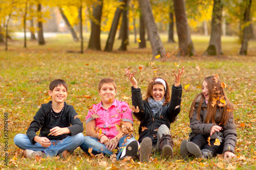 Four teenage boys and girls playing in the autumn nature