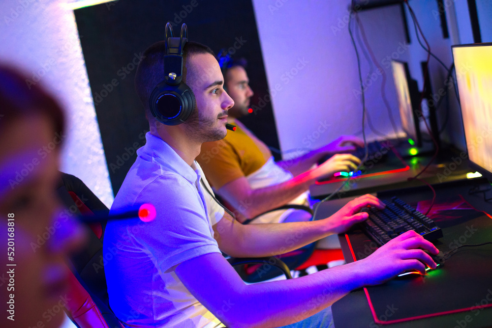 Team of gamers playing computer games at night Team of gamers playing computer games at night