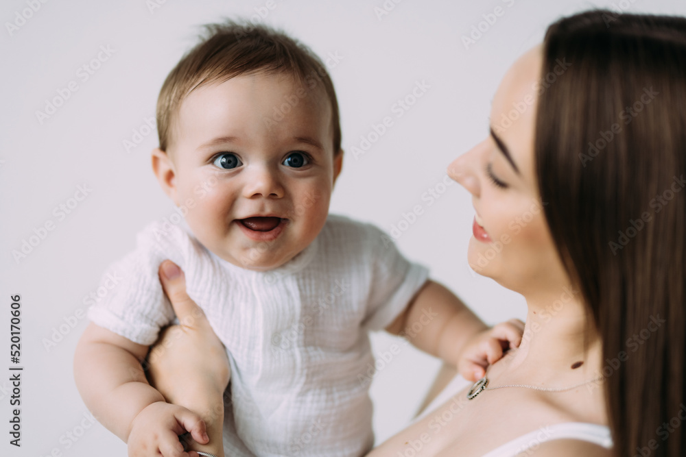 Happy smiling mother with baby having fun together isolated on white background