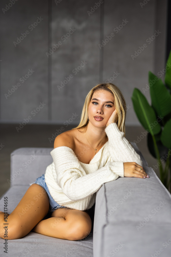 Happy young woman lying on couch and relaxing at home Happy young woman lying on couch and relaxing at home