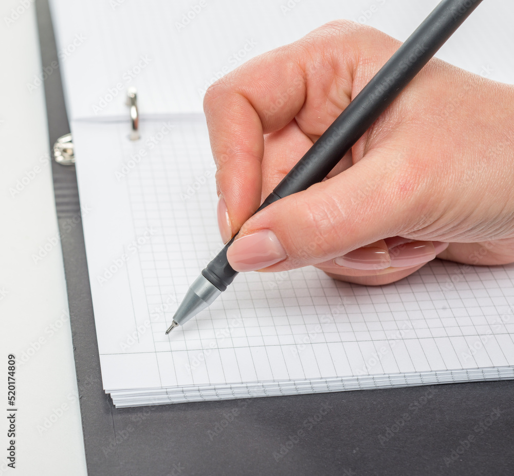 hand with a pen writes close-up isolated on a white background hand with a pen writes close-up isolated on a white background