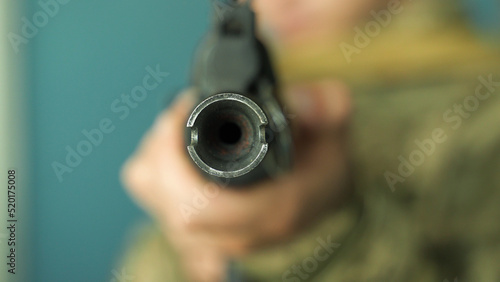 a soldier in camouflage uniform takes aim with his machine gun, preparing to fire close-up. fighting inside the building. firing at the enemy army. Kalashnikov shooting. combat clashes