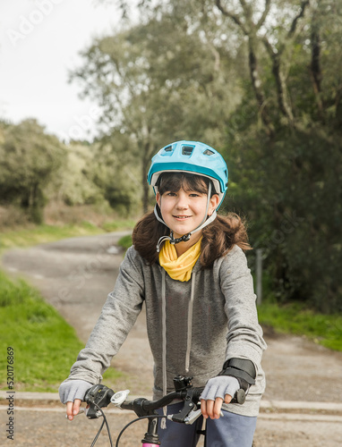 outdoor portrait of a child girl riding a bike, active lifestyle, reacreation leisure time on natural background