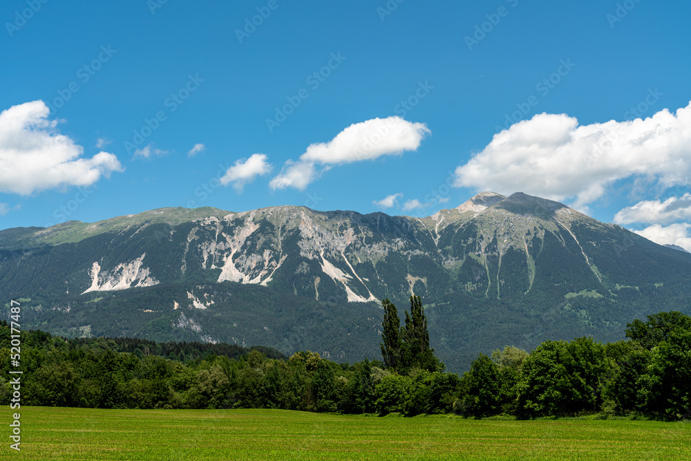 Beautiful panorama view of Veliki Stol (Hochstuhl) massif at border between Slovenia and Austria on a sunny summer day from Bled with blue sky cloud.